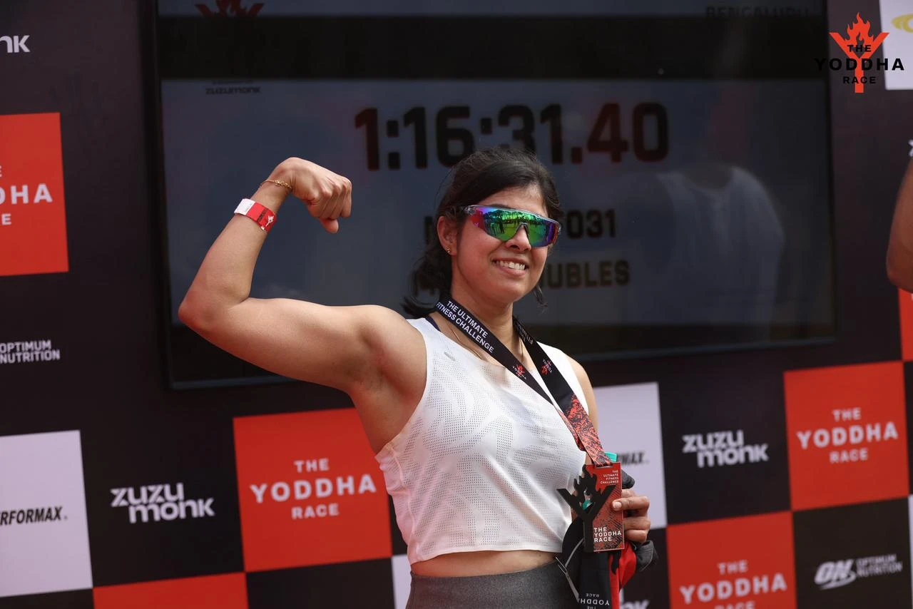 Priya celebrating her finish at a fitness race